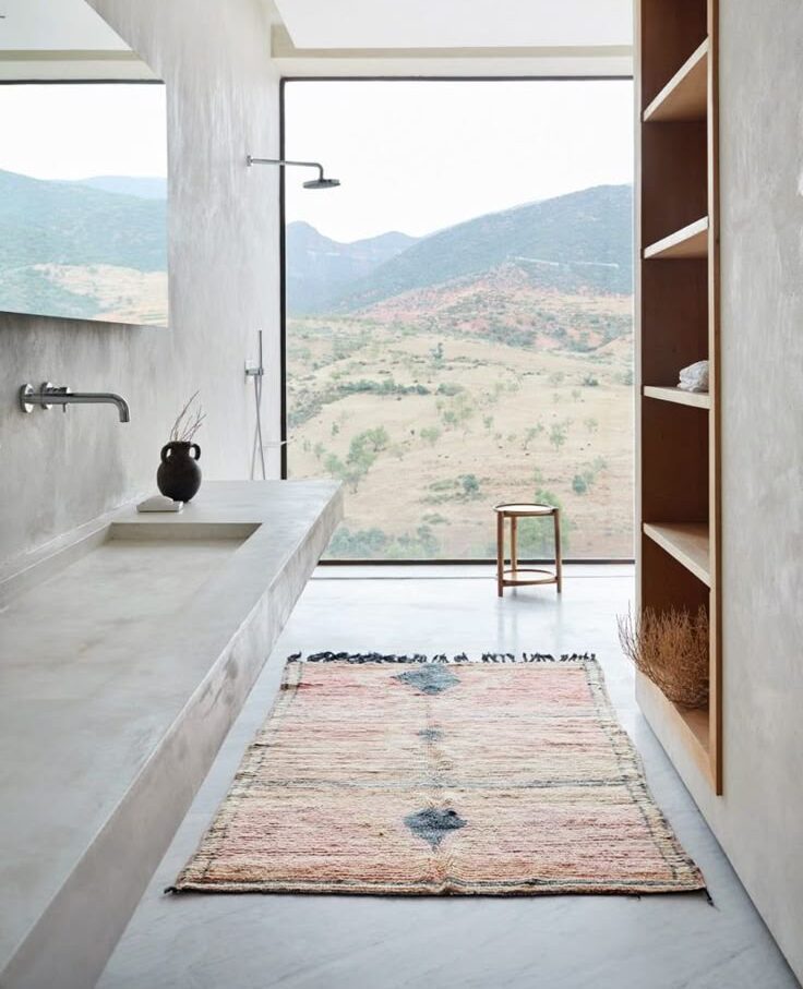 Tadelakt plaster bathroom opening onto a wide natural landscape