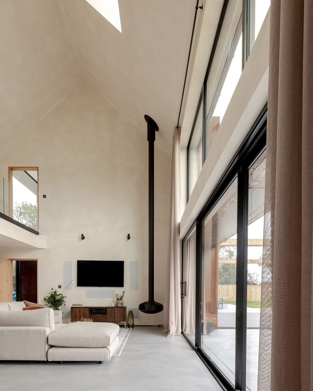 Double-height limewash living room with black-framed windows