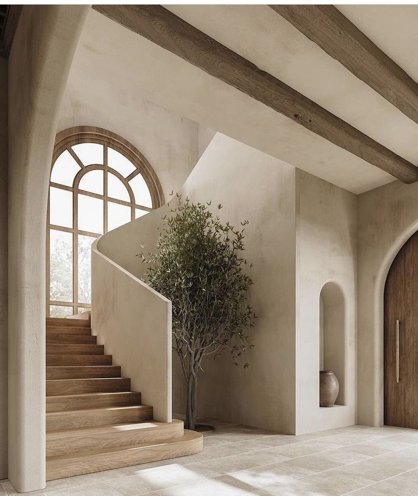 Curved lime plaster staircase wall with soft natural light